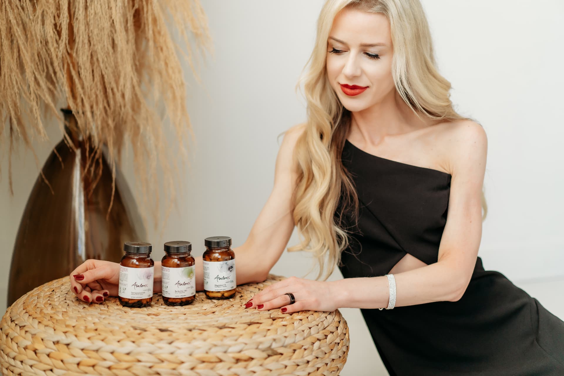 Melanie Avalon looking closely at AvalonX supplement bottles